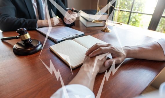 Two individuals sitting across each other, with notes, one with a gavel