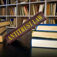 Pile of books and antitrust law near the shelf. Pile of books and antitrust law near the shelf.